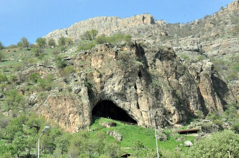 Շանիդար քարանձավի մուտքը՝ Իրաքյան Քրդստանի կանաչապատ ժայռոտ լանջին